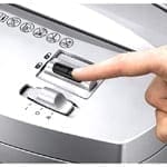 A person is pressing the button on a Powershred® W11C Cross-Cut Shredder.